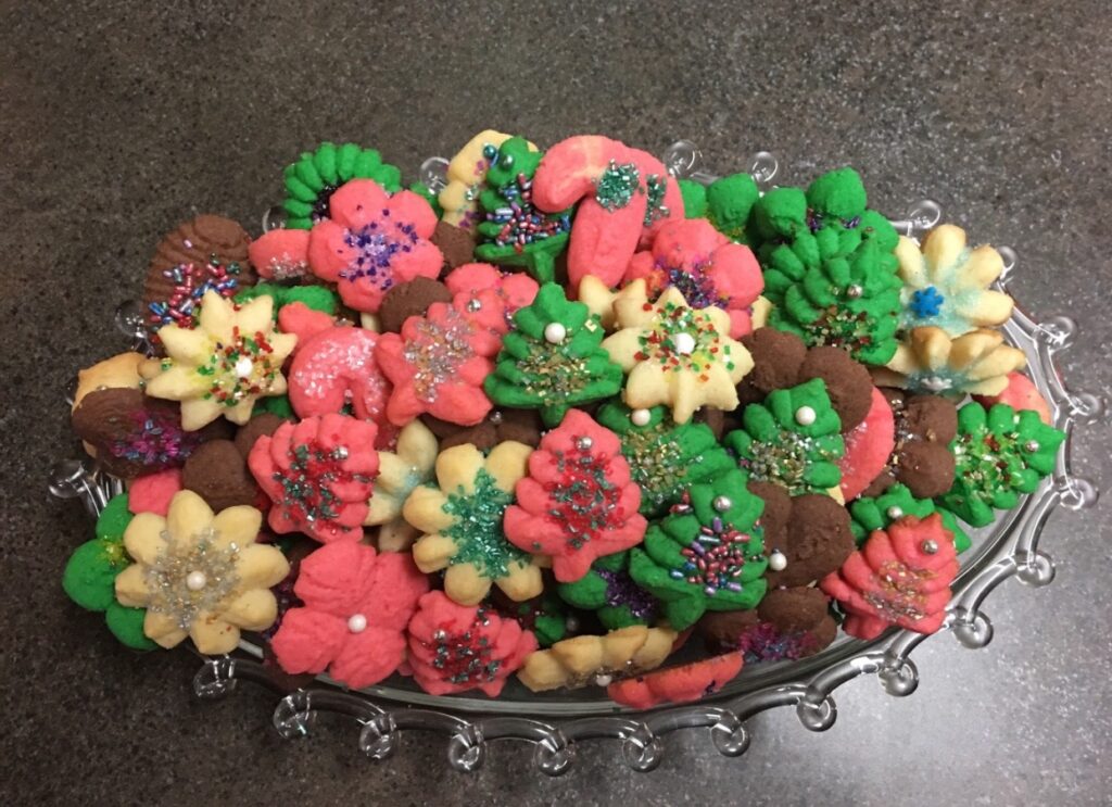 A bowl of cookies that are colorful and decorated.