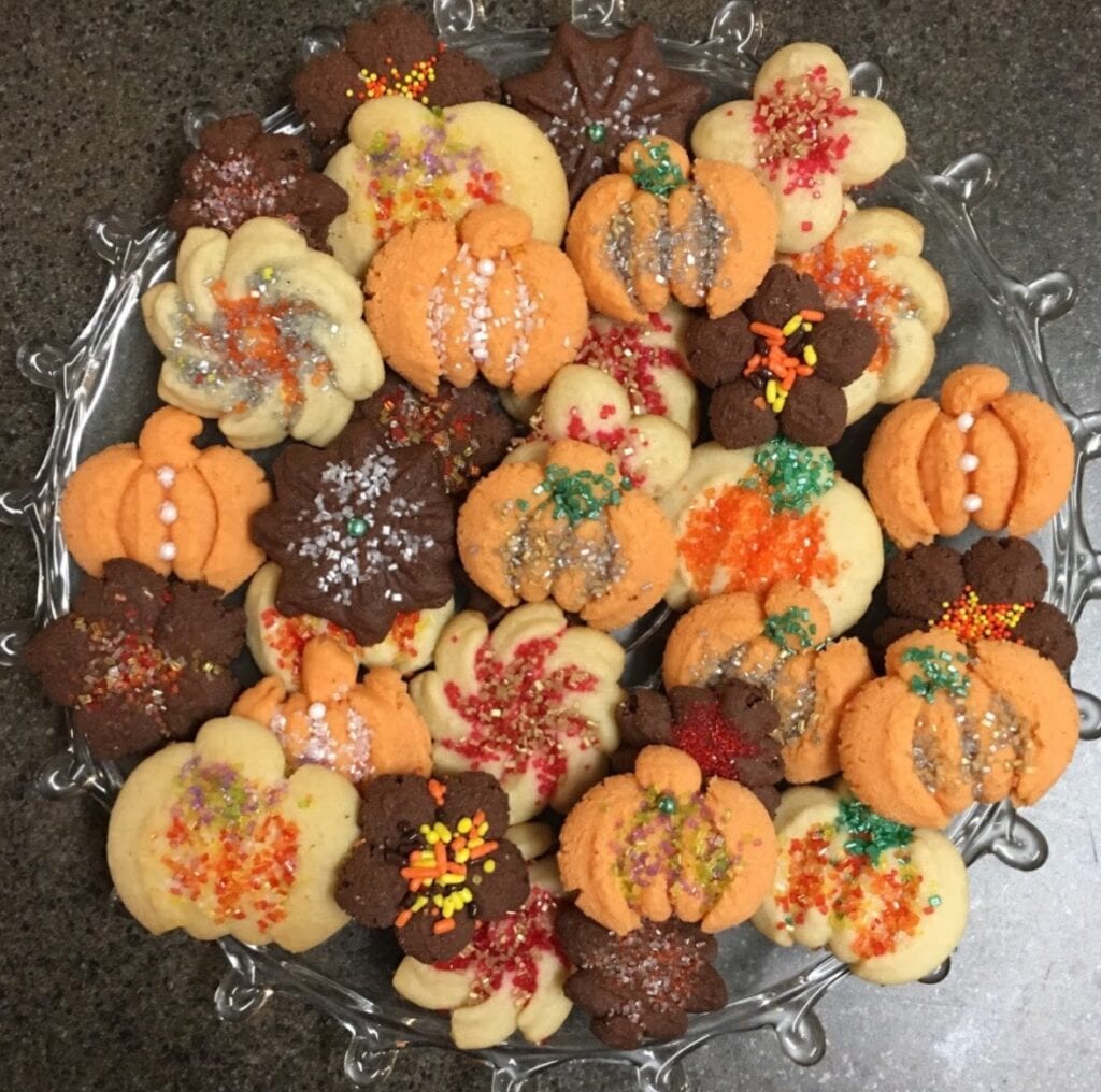 A plate of cookies that are decorated for fall.