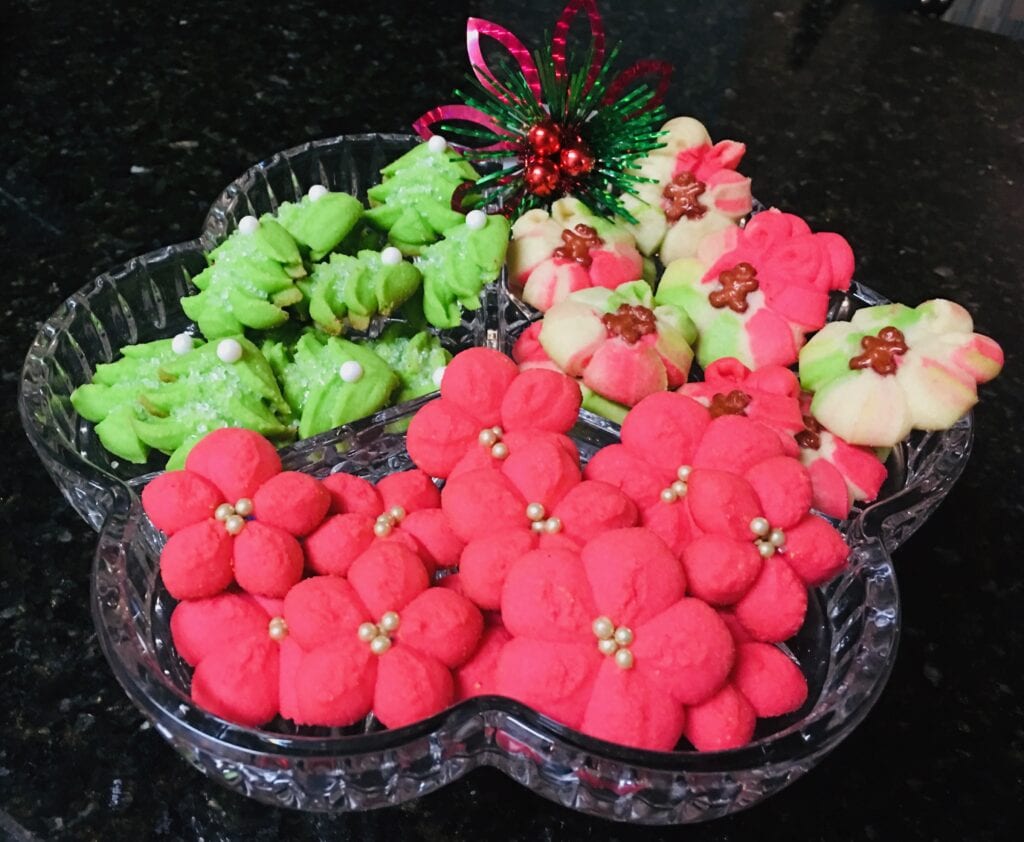 A tray of cookies and other treats in the shape of flowers.