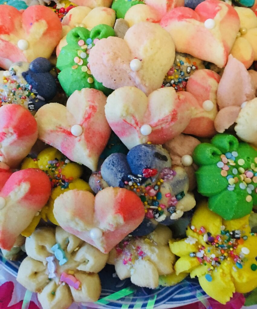 A pile of heart shaped cookies with different colors.