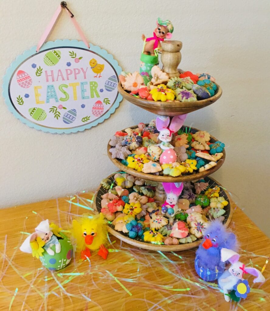 A table with three trays of candy and some paper decorations.
