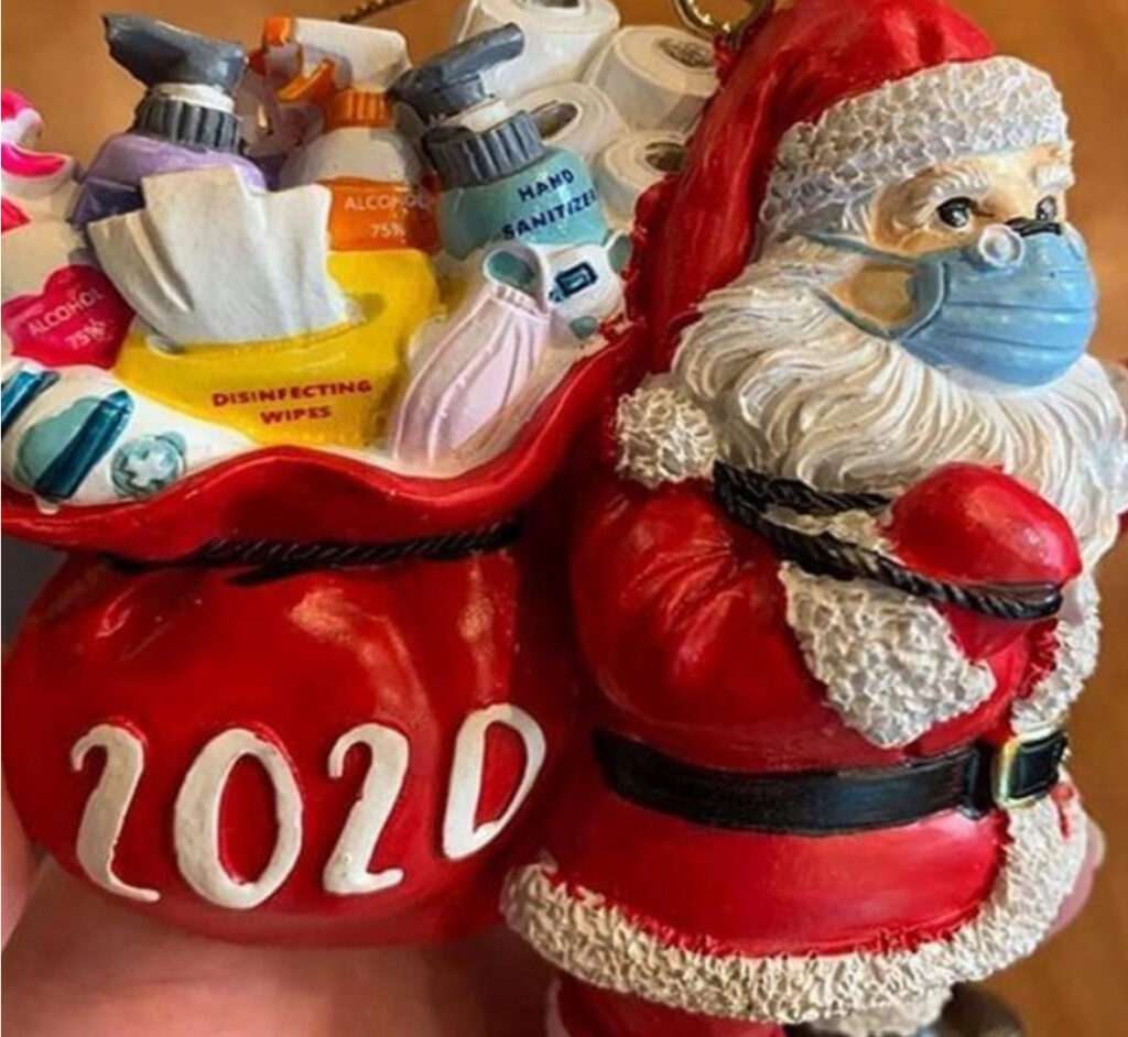 A santa clause ornament with masks and sanitizers.