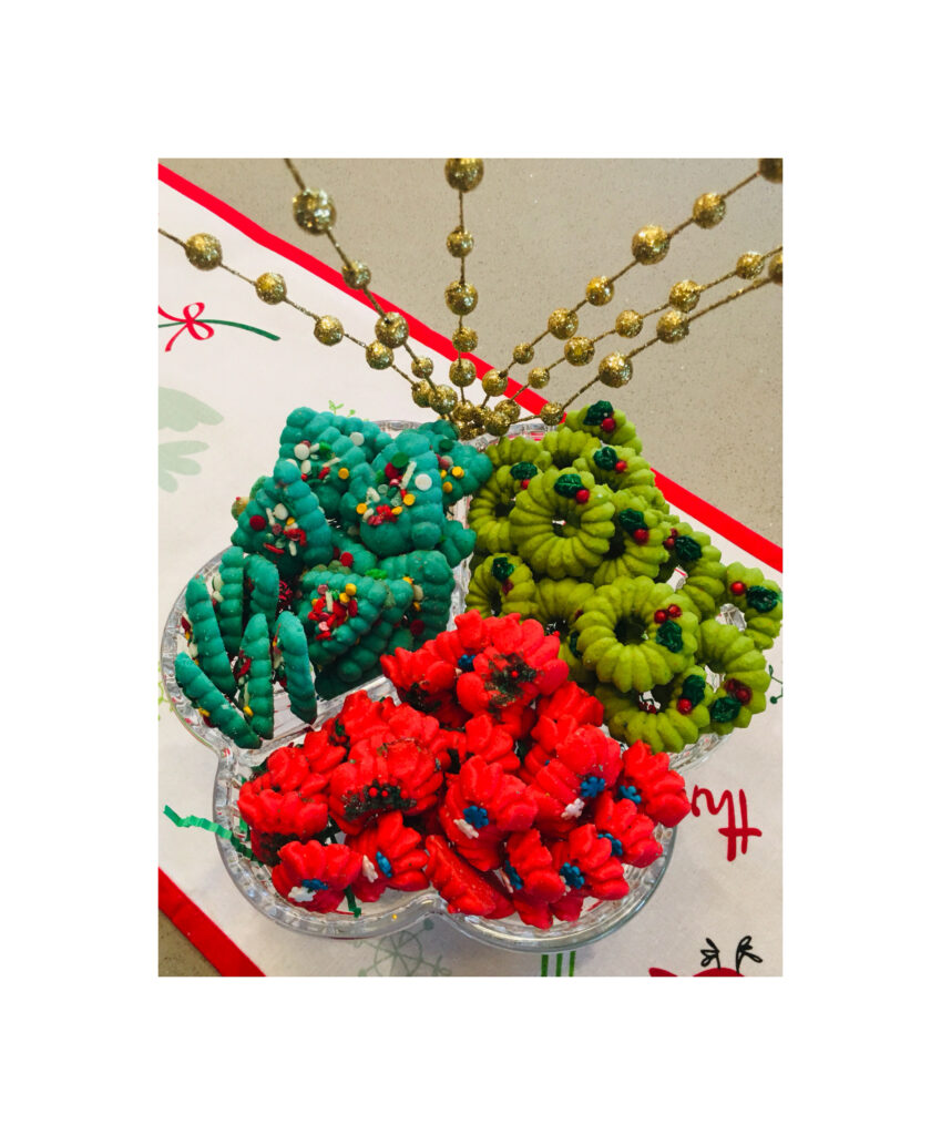 A bowl of colorful christmas cookies on top of a table.
